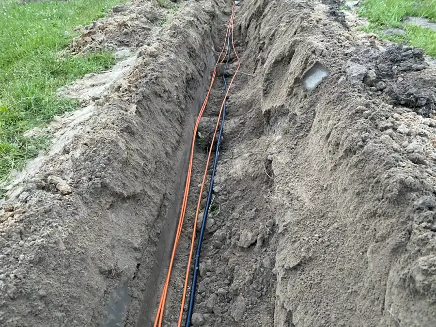 Kable ułożone w wykopie między budynkami